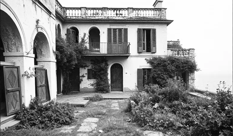 Villa balnéaire abandonnée autour d’une cour envahie par la végétation.