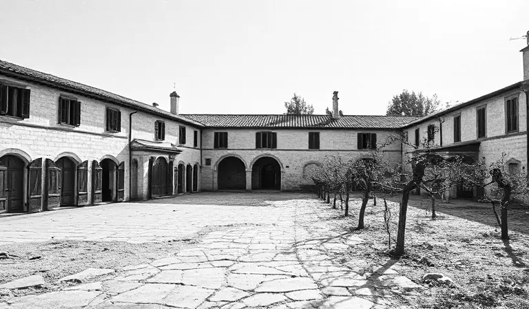 Ancienne propriété viticole autour d’une cour sèche et dégradée.