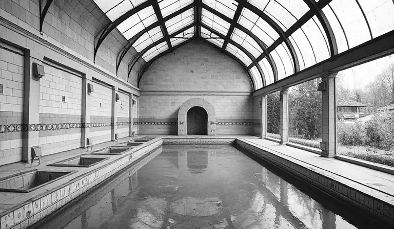 Ancienne salle thermale aux bassins vides et aux carrelages dégradés.