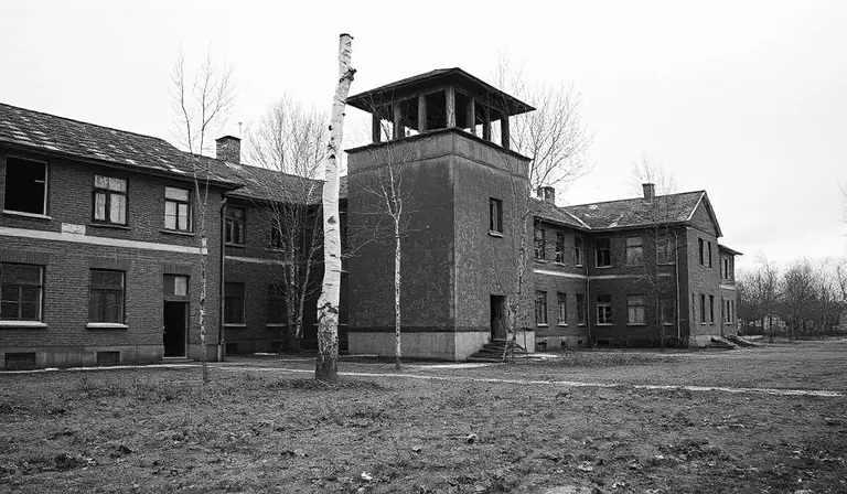 Ancien ensemble militaire abandonné, gagné par les arbres et la rouille.