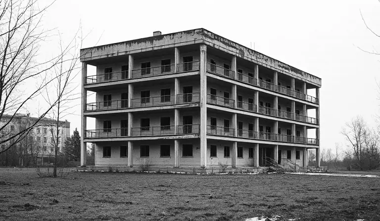 Ancienne usine des eaux, où les conduites en fonte et la charpente rouillée se reflètent dans les flaques.