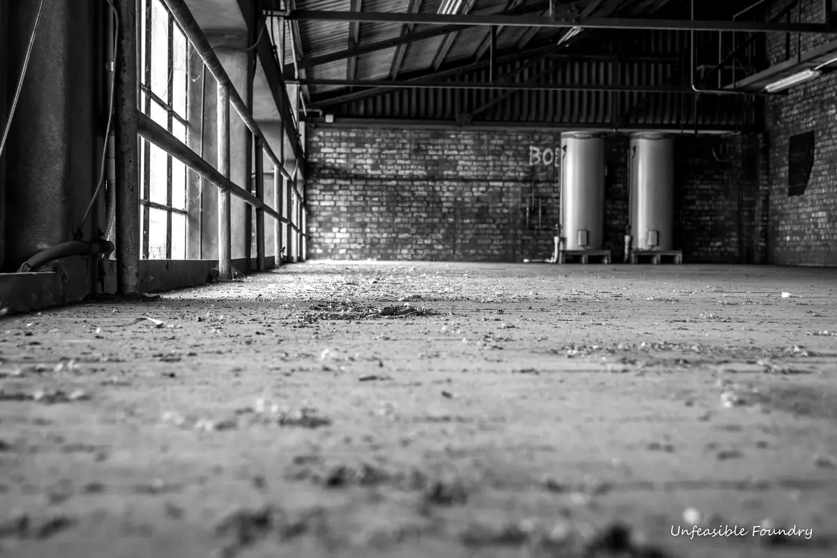 Une grande halle industrielle abandonnée photographiée au ras du sol
