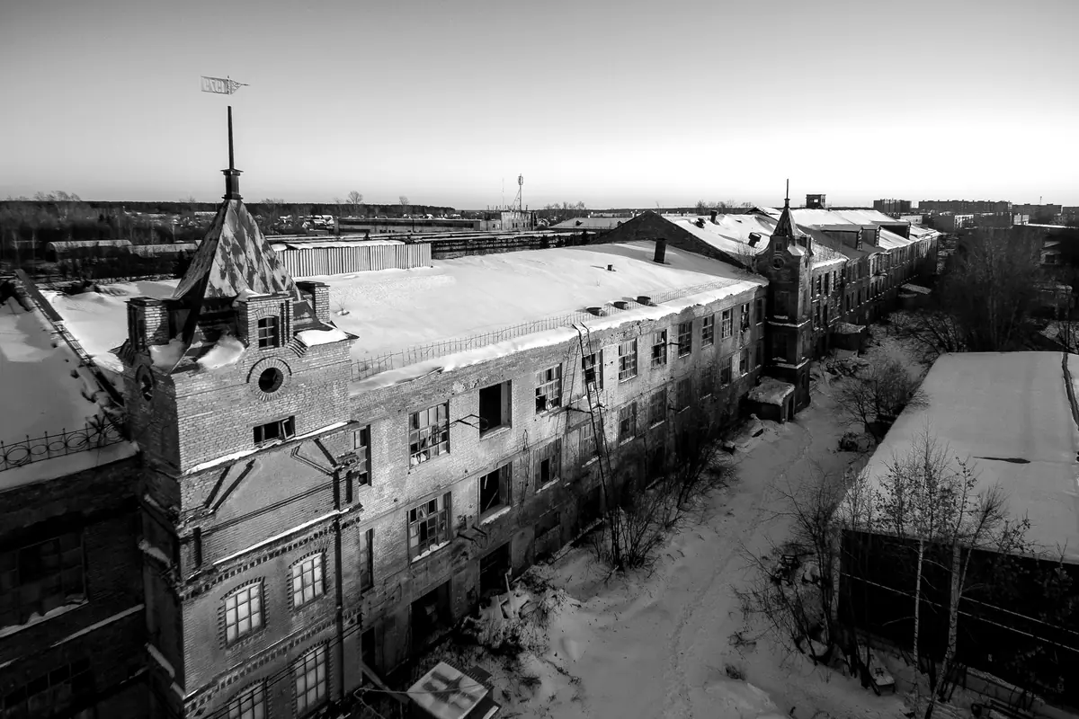 Vue aérienne d’une ancienne usine de briques au coucher du soleil, sous la neige