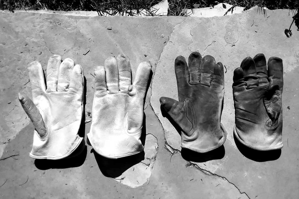 Des gants de travail en cuir usés, posés côte à côte